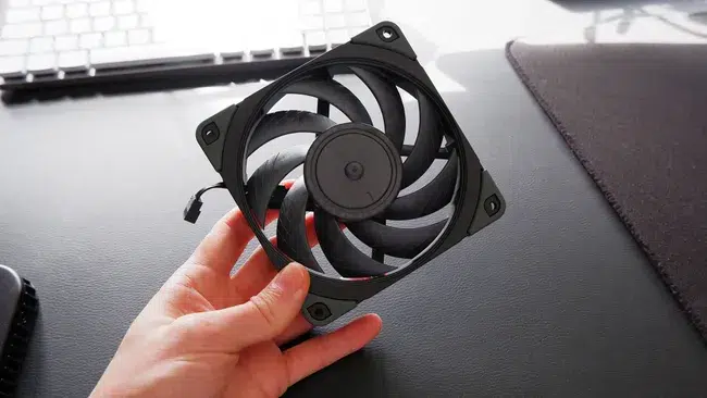 Noctua siyah fanlar ve bej renkli fanlar yan yana masada duruyor, kutu içinde